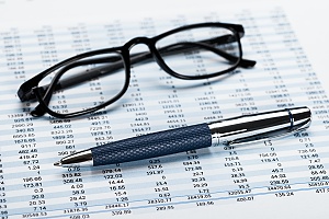 accountant financial records shown with glasses and a pen