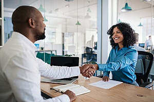 a government contractor shaking hands with a CPA after successful renewal of a contract