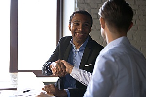 a certified public accountant shaking hands with a government contractor after filing SF 1408