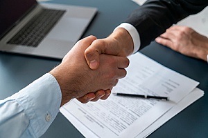 a CPA shaking hands with a business owner after working on government contract bidding