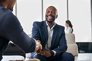 a government contractor shaking hands with a FAR compliance specialist