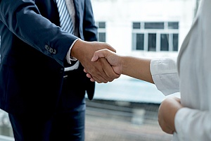 two business owners shaking hands after a successful merger