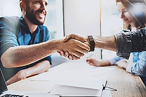 a business owner shaking hands with an outsourced accountant who is assisting with payroll