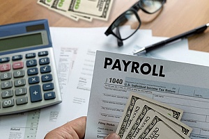 a form 1040 and cash representing payroll