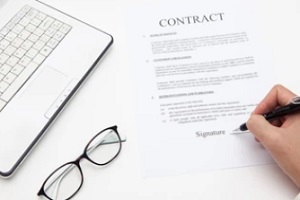 person signing contract with black pen