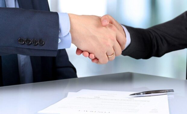 handshake between two colleagues after signing a contract