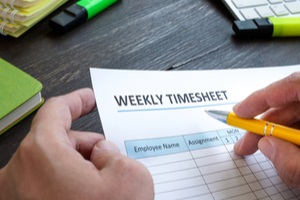 man filing in weekly timesheet for employee
