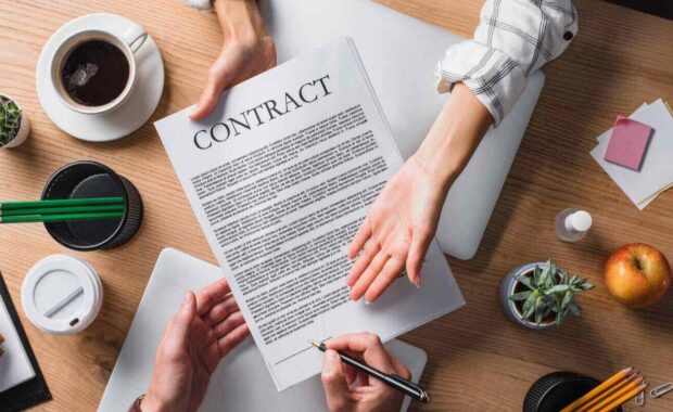 businesspeople signing contract at workplace
