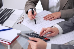 female accountants counting on calculator income for tax