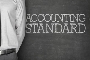 word accounting standards on blackboard with man