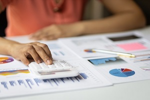 accountant working on desk office with using a calculator to calculate the numbers and audit