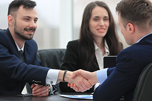 business partners shaking hands over a meeting in a corporate office