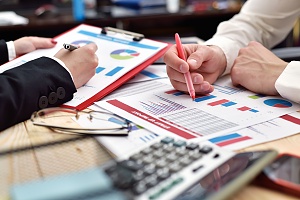 professionals reviewing charts at a paperwork meeting