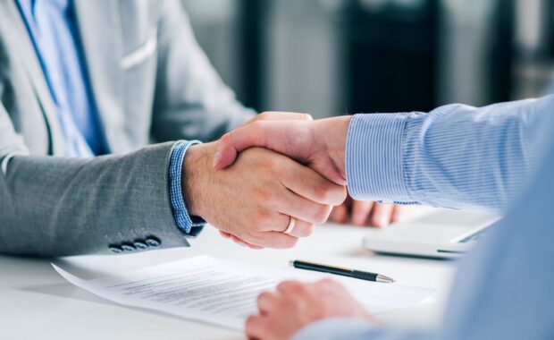 businessmen handshaking over signed contract