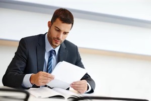 business man, reading and paperwork for financial accounting, expenses and budget report in office