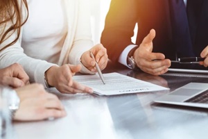 business people discussing contract while working together in sunny modern office