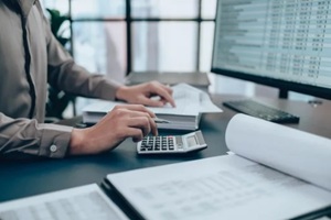 investors working on desk office and using a calculator to calculate balance