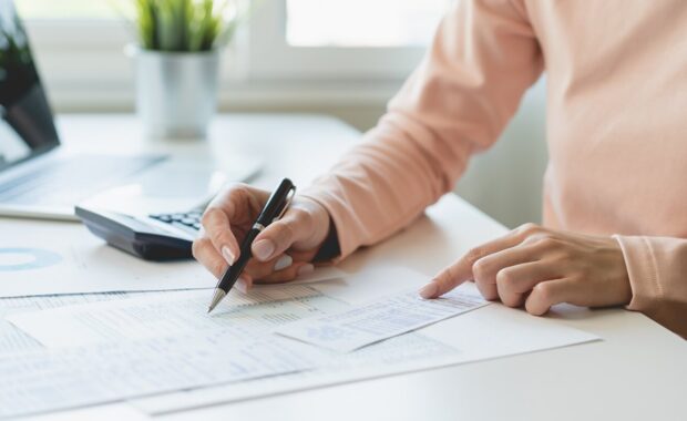 debt asian young woman hand using calculator to calculating money balance from bill and income