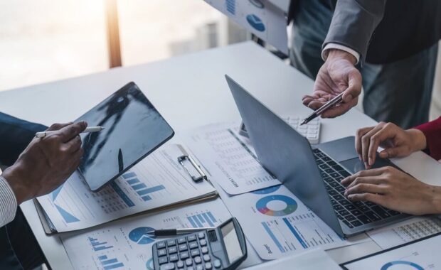 people meeting using laptop computer,calculator,notebook,stock market chart paper for analysis Plans to improve quality next month