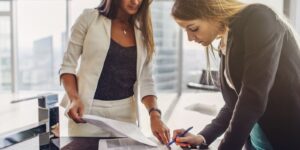 women signing a contract standing in modern appartment