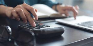 business woman working at office, using calculator to calculate company finance