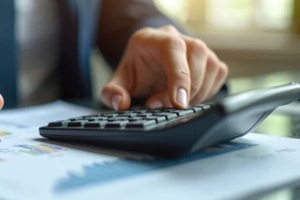entrepreneur analyzes expenses using calculator
