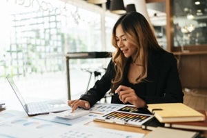 asian business women working with calculator, business document and laptop computer notebook