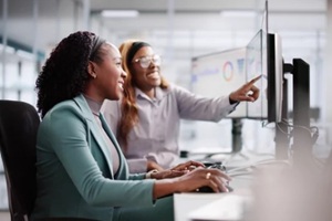 female analyst using multiple screens