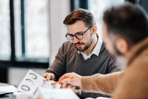colleagues are sitting at the meeting room and discussing charts and statistics