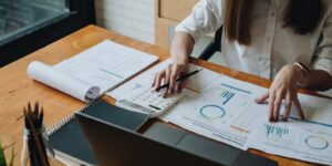 accountant woman checking paperwork from accounting department to analyse number on document