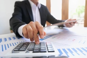 business meeting with hand pointing graph discussion and analysis data charts and graphs and using a calculator to calculate numbers