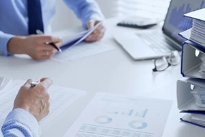 accountants are analyzing financial reports with magnifying glass and documents