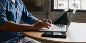 close-up image of a businessman typing on a laptop at his desk illustrates document management