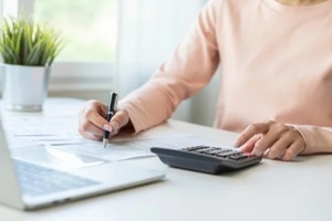 debt asian young woman hand using calculator to calculating money balance from bill and income