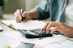 hand using calculator to calculating money balance from bill and income