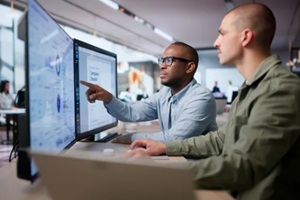 two men analyze compliance data together